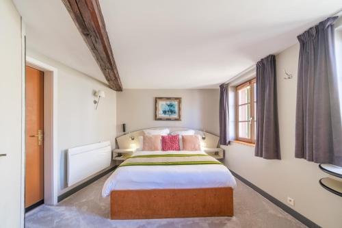Postel nebo postele na pokoji v ubytování L'Hostellerie du Château