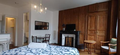 - une chambre avec un lit, une cheminée et une télévision dans l'établissement La Suite Sinatle Rennes Hyper Centre - 2 personnes, à Rennes