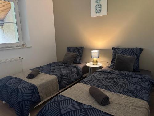 3 lits dans une chambre avec une lampe sur une table dans l'établissement Le trente 30, à Jeuxey