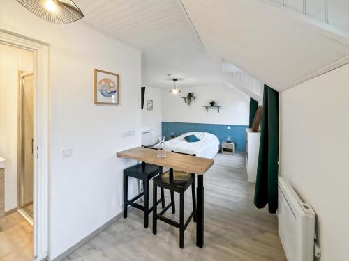 une chambre avec une table et un lit en arrière-plan dans l'établissement Studio Horizon Bleu, à Criel-sur-Mer