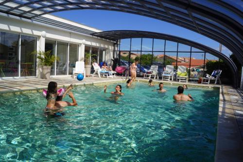 a group of people playing in a swimming pool at Appartements Les Déferlantes Mimizan-plage in Mimizan