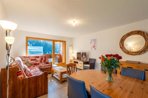 ein Wohnzimmer mit einem Tisch und einer Blumenvase darauf in der Unterkunft Appt Cosy centre ville à 5 min des stations de ski in Saint-Jean-de-Sixt