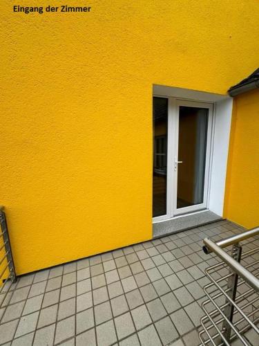 a building with a yellow wall with a door at Apartments & Zimmer Jembke in Jembke