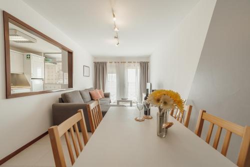 a kitchen and living room with a table with flowers on it at Espinho Modern 3 Bedroom Apartment by Vacationy in Porto