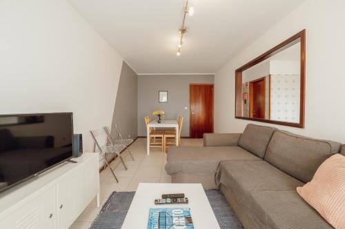 a living room with a couch and a tv at Espinho Modern 3 Bedroom Apartment by Vacationy in Porto