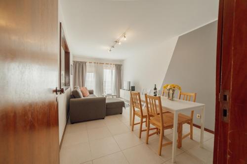 a kitchen and living room with a table and chairs at Espinho Modern 3 Bedroom Apartment by Vacationy in Porto