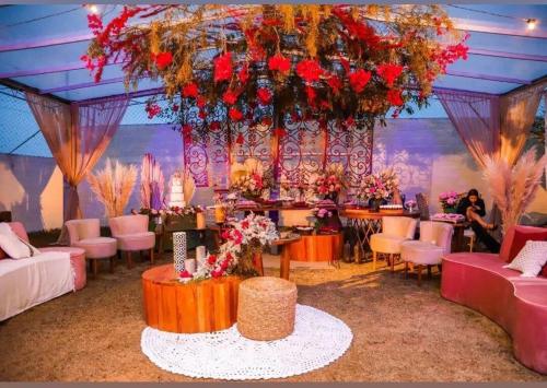 une pièce avec un grand lustre avec des fleurs et des tables dans l'établissement Casa de Campo em Juiz de Fora Granja 6 de Maio, à Chácara