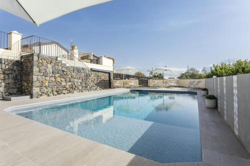 a swimming pool in a house with a stone wall at B&B Badimà in Fleri