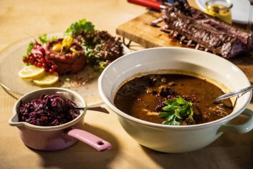 a bowl of soup next to a plate of food at Gasthaus Kampenwand in Bernau am Chiemsee