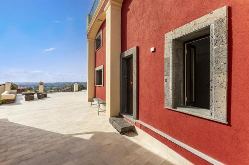 a red building with a large window on the side of it at B&B Badimà in Fleri