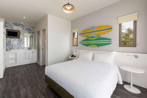 a hotel room with a bed and a bathroom at Radisson Blu Resort Taghazout Bay Surf Village in Taghazout
