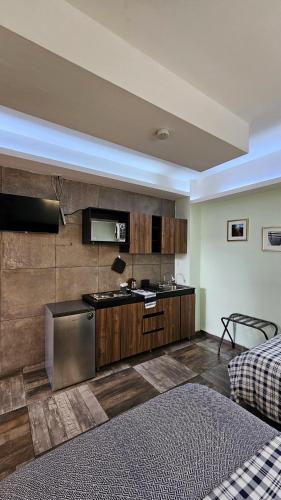 a kitchen with a sink and a stove in a room at A30 SUITE BLACK PLUS para 1 a 3 personas, ESPECIALISTAS EN CORTAS, MEDIANAS Y LARGAS ESTANCIAS , en IZCALLI TEPOTZOTLAN perfecto para Familias, Turistas, Contratistas, Estudiantes, Empresas A sólo 5 min Izcalli 5 min Esmeralda 20 min Satélite 25 min AIFA in Cuautitlán Izcalli