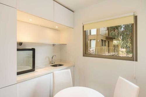 a small white kitchen with a sink and a window at Radisson Blu Resort Taghazout Bay Surf Village in Taghazout