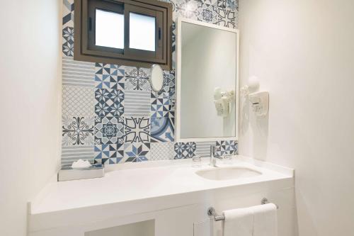 a bathroom with a sink and a mirror at Radisson Blu Resort Taghazout Bay Surf Village in Taghazout
