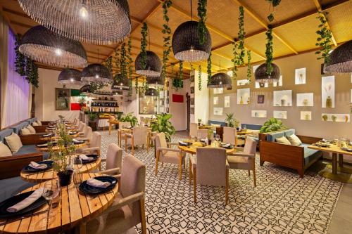 a restaurant with tables and chairs and pendant lights at Radisson Blu Resort Taghazout Bay Surf Village in Taghazout