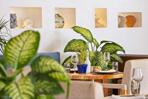 a table with glasses and plants on it at Radisson Blu Resort Taghazout Bay Surf Village in Taghazout