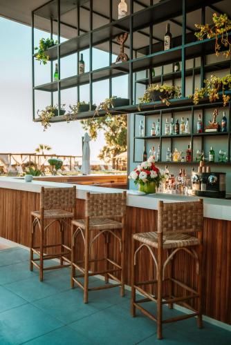 a bar with two chairs and a counter with plants at Radisson Blu Resort Taghazout Bay Surf Village in Taghazout