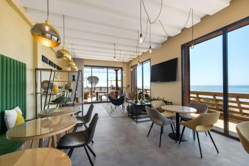 a restaurant with tables and chairs and a view of the ocean at Radisson Blu Resort Taghazout Bay Surf Village in Taghazout
