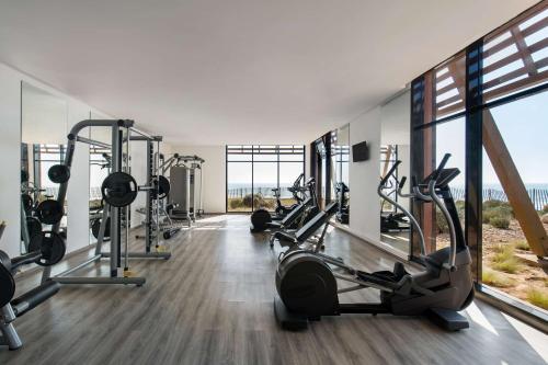a gym with treadmills and elliptical machines at Radisson Blu Resort Taghazout Bay Surf Village in Taghazout