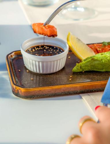 a plate of food with a bowl of sauce at Radisson Blu Resort Taghazout Bay Surf Village in Taghazout