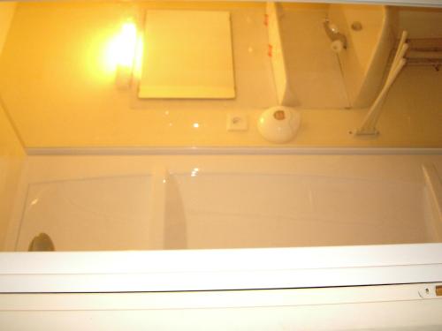 La salle de bains est pourvue d'une baignoire et d'une lumière sur le mur. dans l'établissement hotellerie LE GRILLADOU, à Labastide-dʼAnjou