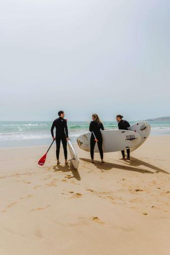 a group of people standing on the beach with surfboards at Radisson Blu Resort Taghazout Bay Surf Village in Taghazout