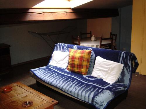 - un canapé bleu avec des oreillers dans le salon dans l'établissement hotellerie LE GRILLADOU, à Labastide-dʼAnjou