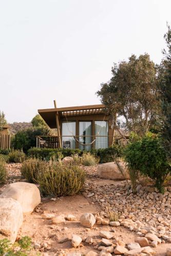 a house on a hill with rocks and trees at Radisson Blu Resort Taghazout Bay Surf Village in Taghazout