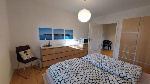 a bedroom with a bed and a desk and a chair at Wolke 1 in Seebruck