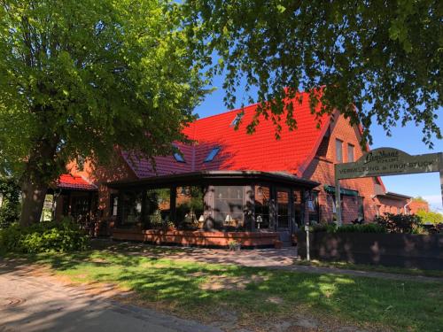 a building with a red roof on a street at Landhaus Schlunt in Wustrow
