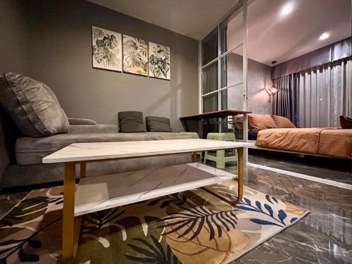 a living room with a couch and a table at Modern2 1BR at Bangson in Bangkok