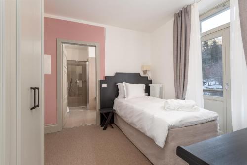 a bedroom with a large bed and a window at Villa Carona Hotel & Spa in Carona