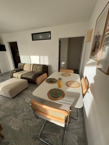 un salon avec une table et un canapé dans l'établissement T3 Rénové vu Port Clim et Wifi, à Mauguio