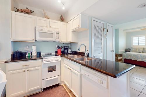 a kitchen with white cabinets and a sink at Plantation Dunes #5101 in Gulf Shores
