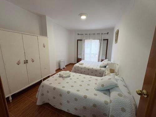 a bedroom with two beds and a window at Casa Rosa in Trevélez