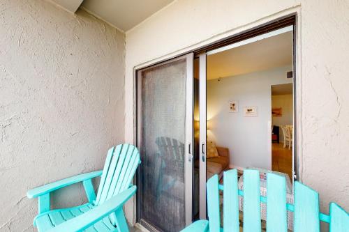 a pair of blue chairs sitting next to a window at Plantation Dunes #5101 in Gulf Shores