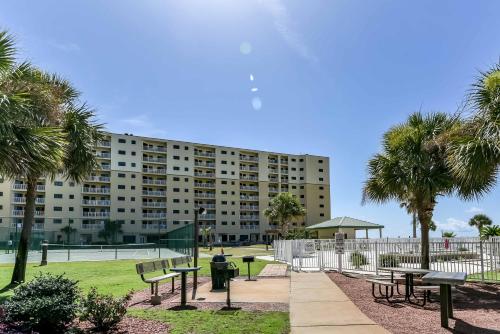 a park with benches and palm trees in front of a building at Plantation Dunes #5101 in Gulf Shores