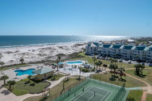 an aerial view of a resort with a tennis court and the beach at Plantation Dunes #5101 in Gulf Shores