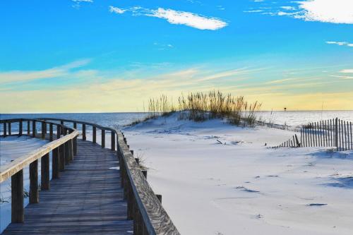 a wooden boardwalk to the beach in the sand at Plantation Dunes #5101 in Gulf Shores