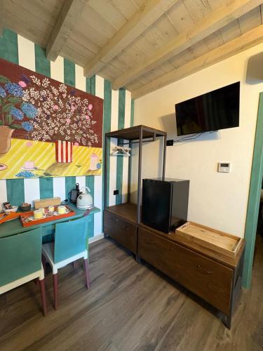 a room with a table and a tv on a wall at B&B Villa la Canonica con piscina a Padernello in Farfengo