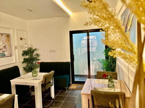 金沙萨Ranzol Hotel and Guest House的餐厅设有2张桌子和椅子以及窗户。