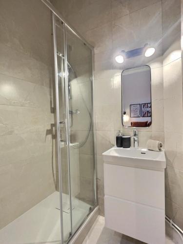 une salle de bain avec une douche, un lavabo et un miroir dans l'établissement Romance Mâconnaise, à Mâcon