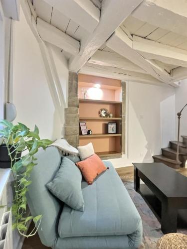 un salon avec un canapé bleu et une table dans l'établissement Romance Mâconnaise, à Mâcon