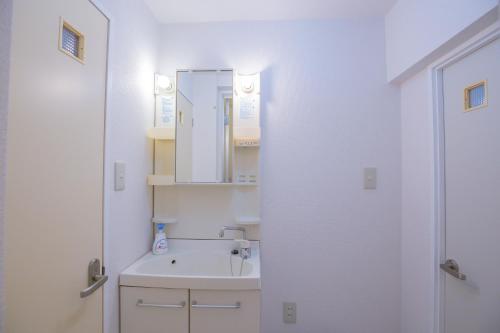 a white bathroom with a sink and a mirror at 新宿駅 西武新宿駅近 歌舞伎町の快適ゲストハウス LoE3 in Tokyo