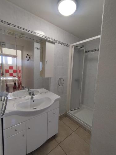 une salle de bain blanche avec un lavabo et une douche dans l'établissement Studio Central, à Canet