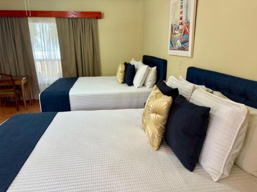 a hotel room with two beds with pillows at Hotel Delfin Playa Bejuco in Esterillos Este