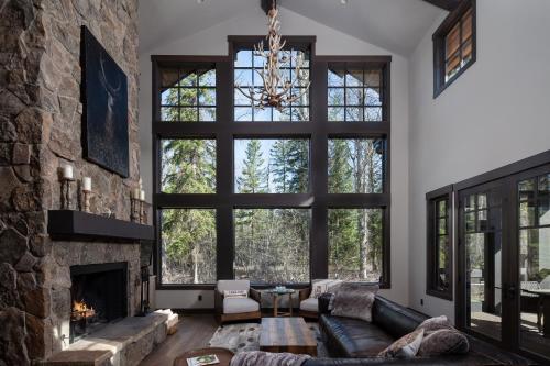 a living room with a large stone wall at Lodge at Whitefish Lake in Whitefish
