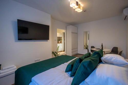 a bedroom with a large bed with green pillows at Happy Home Apartman in Miskolctapolca