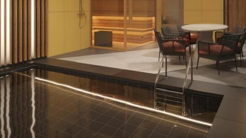 a pool in a lobby with chairs and a table at Holiday Inn Tashkent City by IHG in Tashkent