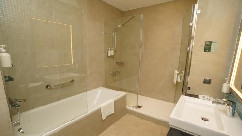 a bathroom with a shower and a tub and a sink at Holiday Inn Tashkent City by IHG in Tashkent